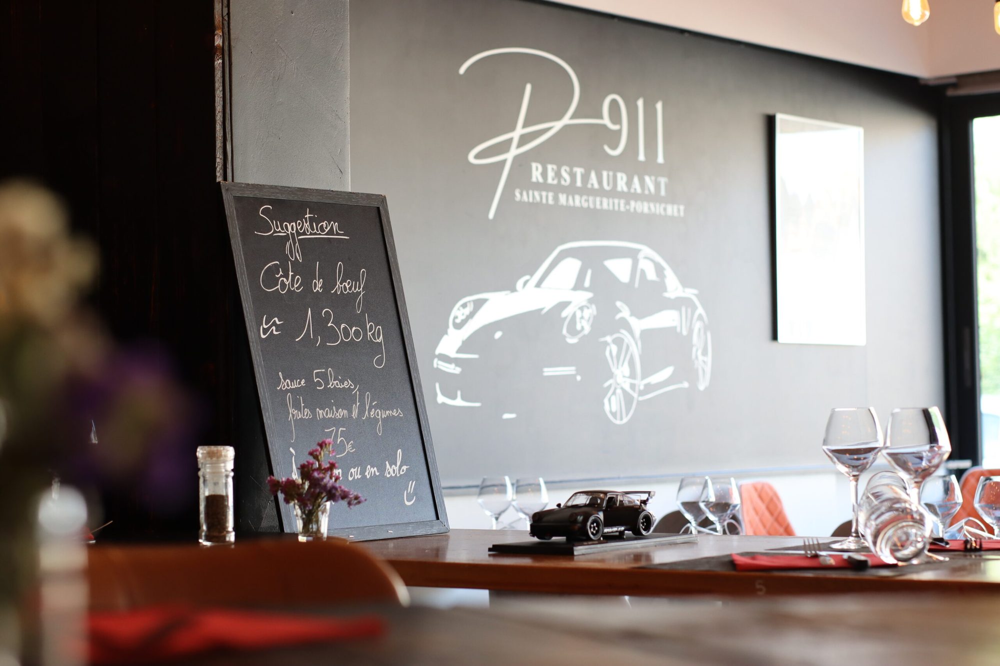 La salle du P911 avec l'ardoise des suggestions et la fresque Porsche 911